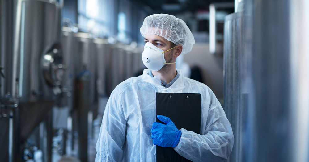 Man wearing protective equipment in food lab