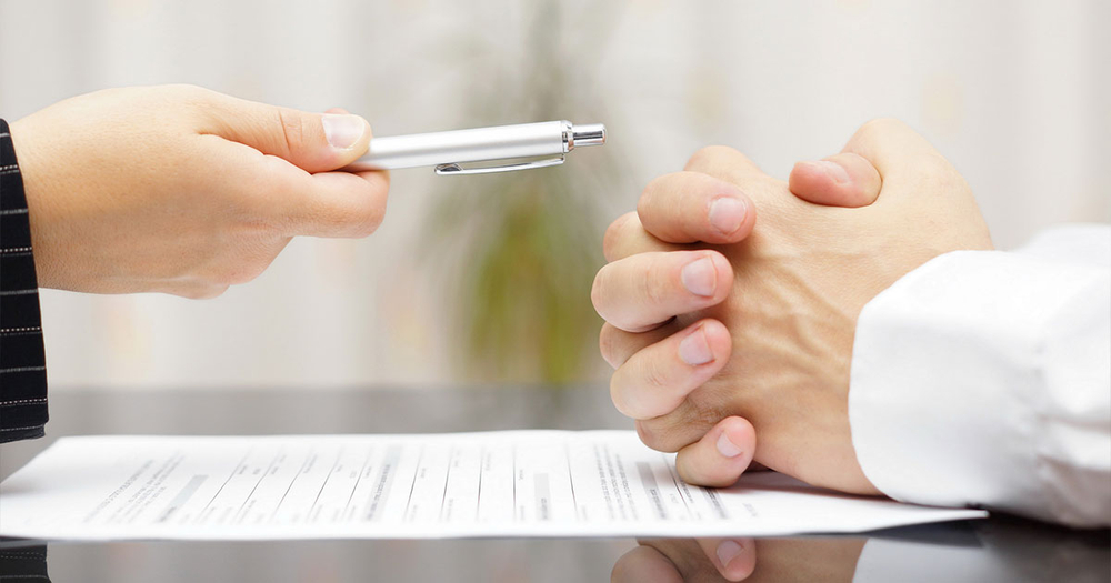 Woman-handing-man-pen-to-sign-contract