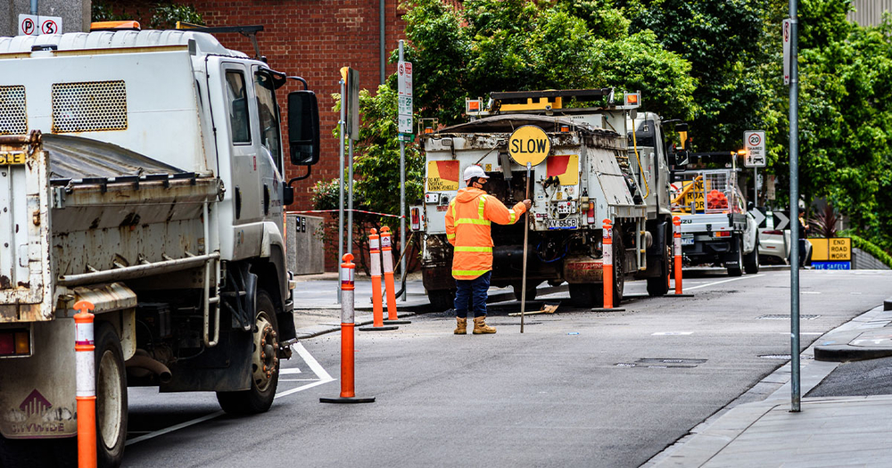 Traffic control worker holding slow sign