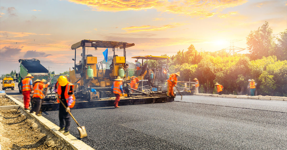 Workers adding new asphalt to road