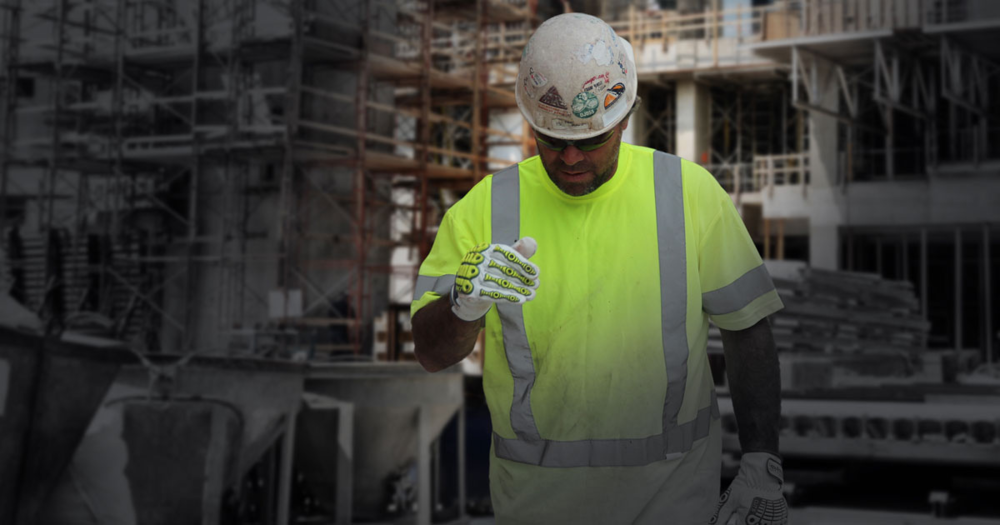 A construction worker wearing a white hard hat and safety gloves.