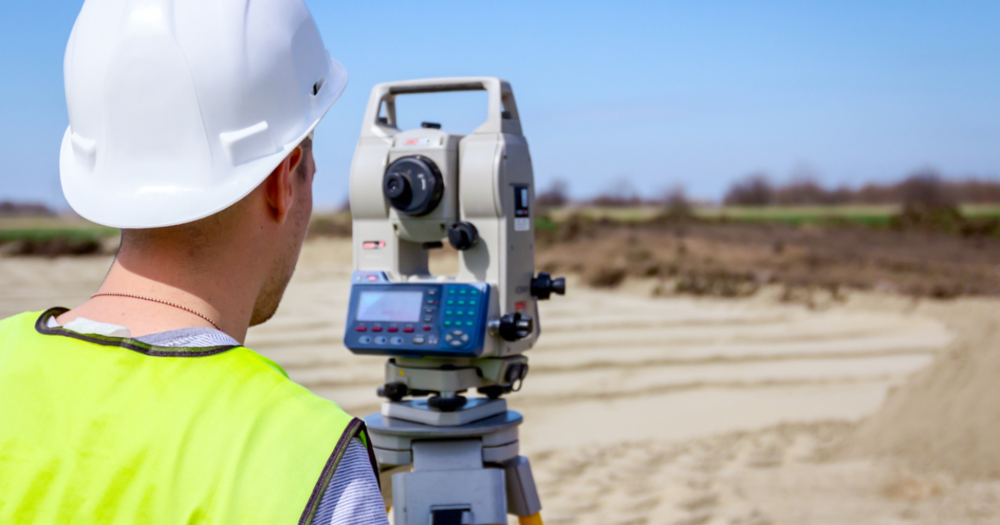 A land surveyor using a total station from Baseline Equipment to survey land.