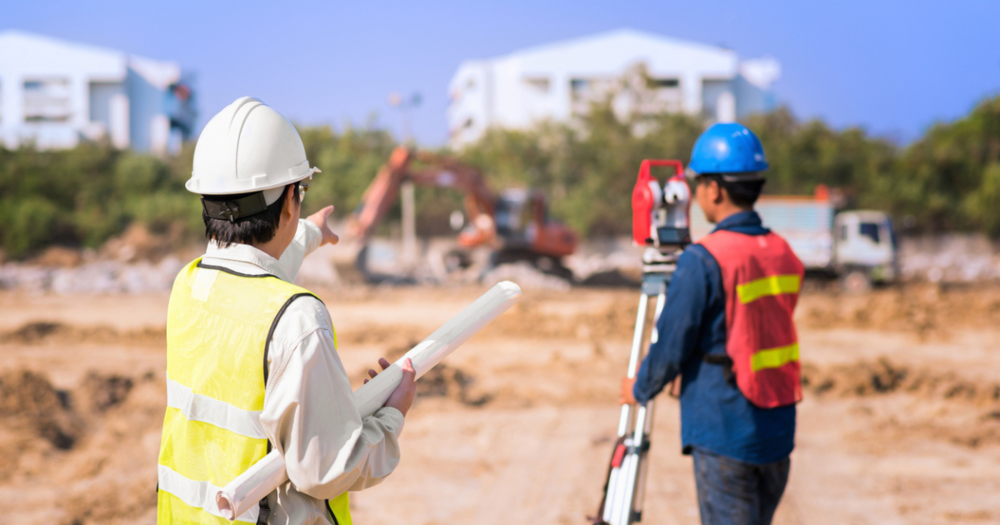 Land surveyors at a construction site using real time kinetic survying equipment.