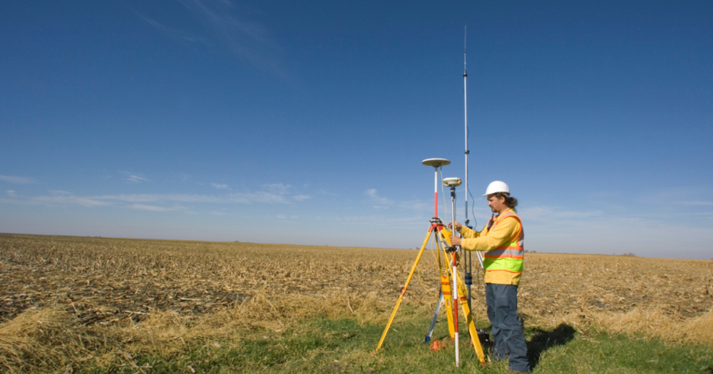 A surveyor using GPS land surveying equipment.