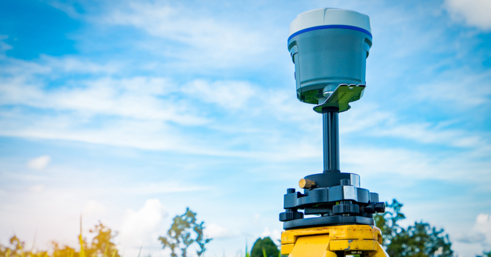 A GPS survey equipment against a blue sky.