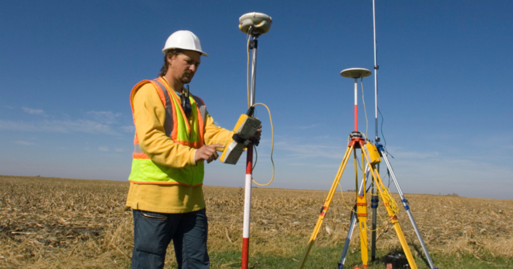 A land surveyor using a GPS unit for a land survey.