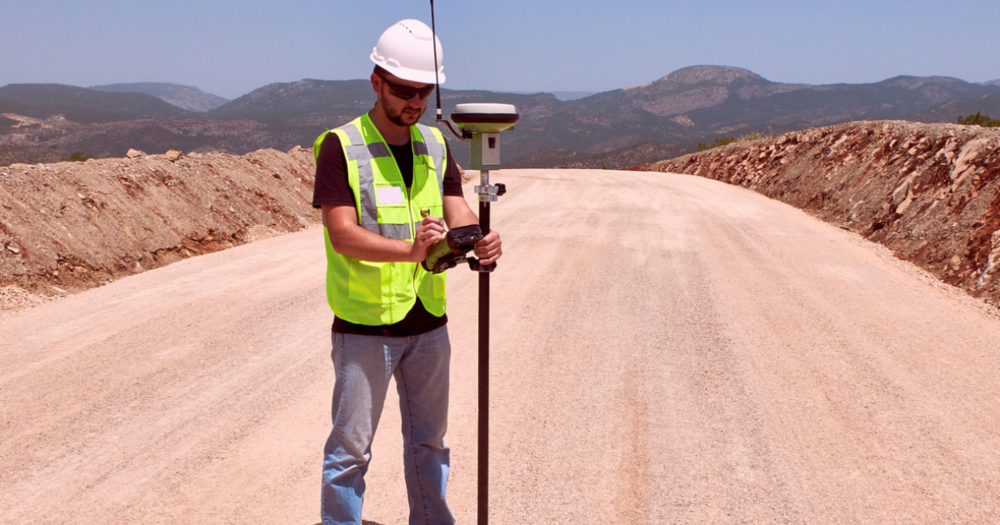 A land surveyor using his GPS land survey equipment with updated software and firmware.