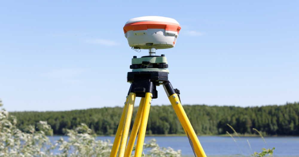 GPS land survey equipment near a lake.